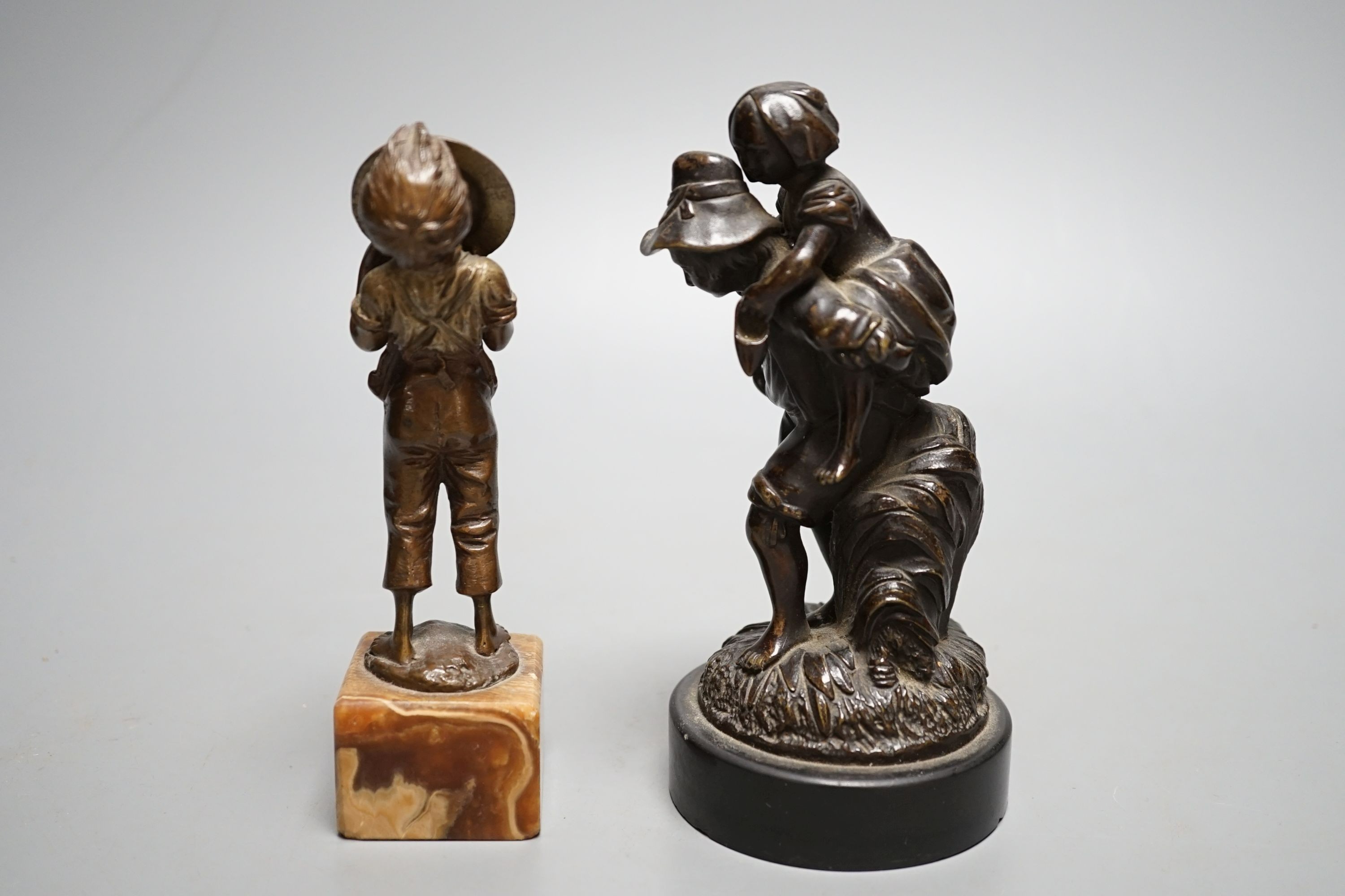 An early 20th century bronze of a boy licking a plate and a Victorian bronze group - tallest 15cm